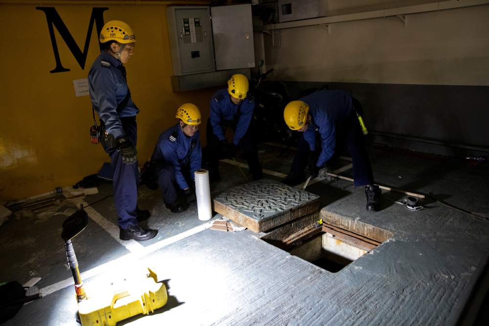 Fire services department officers close a sewer which is believed to be an escape route for anti-government protesters after being barricaded by police officers in Hong Kong November 23, 2019. u00e2u20acu2022 Reuters pic