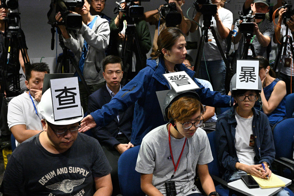 Journalists including Ronson Chan Ron-sing (left) wearing protective press helmets with Chinese characters that read u00e2u20acu02dcInvestigate Police Brutality Stop Police Liesu00e2u20acu2122 at the police headquarters in Hong Kong November 4, 2019. u00e2u20acu201d AFP pic 