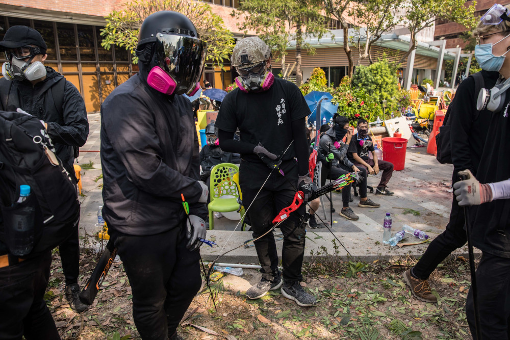 A protester (centre) holds a bow and arrow as protesters gather at The Hong Kong Polytechnic University, in Hong Kong November 14, 2019. u00e2u20acu201d AFP pic 