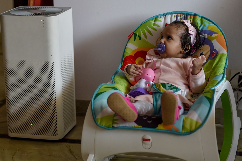 In this photograph taken on November 6, 2019, six-month-old Ayesha rests near an air purifier at her residence in New Delhi. u00e2u20acu201d AFP pic  