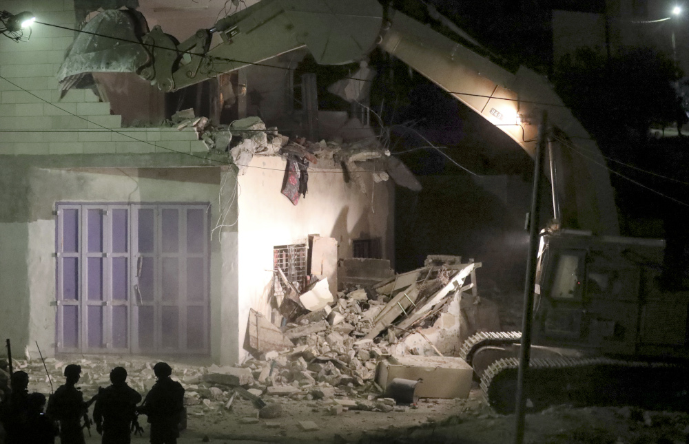 Israeli security forces keep watch as machinery demolish a house belonging to a Palestinian assailant who reportedly carried out an attack against Israelis in August, November 28, 2019 in Beit Kahel near Hebron. u00e2u20acu201d AFP pic