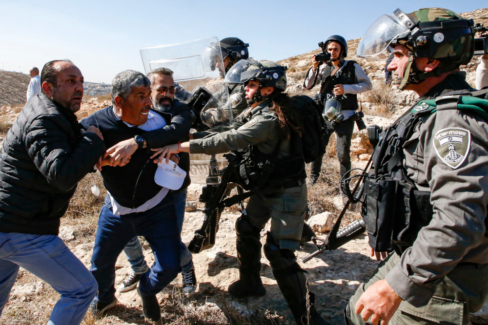 Israeli border guards scuffle with Walid Assaf (2nd left), the Palestinian Authorityu00e2u20acu2122s Chairman of the Commission Against the Wall and Settlements, and other demonstrators in Surif, north of Hebron in the occupied West Bank November 22, 2019. u00e2u20acu201d AFP 