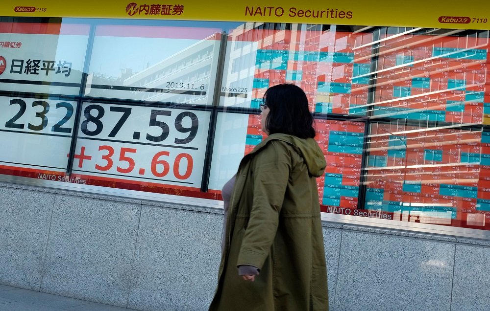 A pedestrian walks in front of an electric quotation board displaying the numbers on the Nikkei 225 index on the Tokyo Stock Exchange in Tokyo November 6, 2019. u00e2u20acu201d AFP pic 