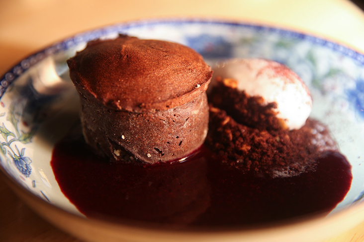 Chocolate lava cake served with organic mulberry sauce, coconut sorbet and a crumble made with cacao, almonds and coffee.