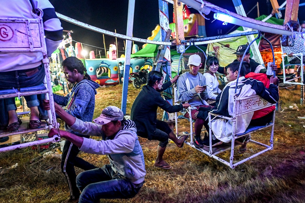 This photo taken on November 6, 2019 shows Aung Sein Phyo (centre), 22, and other crew members operating a human-powered ferris wheel in Taunggyi, Shan state, Myanmar. — AFP pic