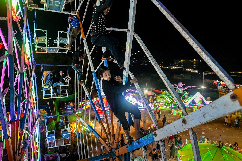 This photo taken on November 6, 2019 shows Aung Sein Phyo (centre), 22, and other crew members operating a human-powered ferris wheel in Taunggyi, Shan state, Myanmar. u00e2u20acu201d AFP pic