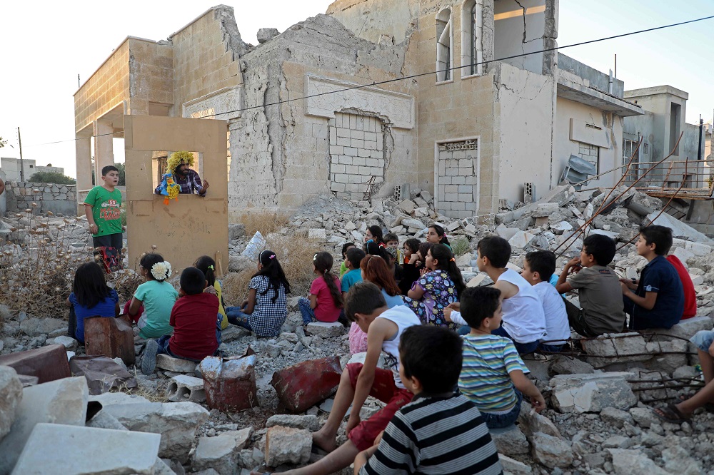 Syrian puppeteer Walid Abu Rashed performs a puppet act for children amid the rubble of damaged buildings in Syria's northwestern city of Saraqib in the Idlib province September 29, 2019. u00e2u20acu201d AFP pic 