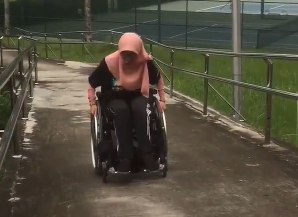Wife of Paralympic tennis player Muhammad Firdaus Ibrahim tries riding a wheelchair up the hill to get a feel of her hubbyu00e2u20acu2122s training. u00e2u20acu201d Picture via Twitter/zafidos