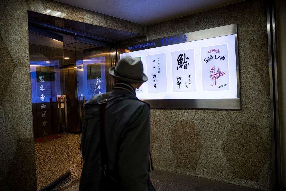 A man walks past the board of Sukiyabashi Jiro sushi restaurant (second from right) in Tokyo November 26, 2019. u00e2u20acu201d AFP pic