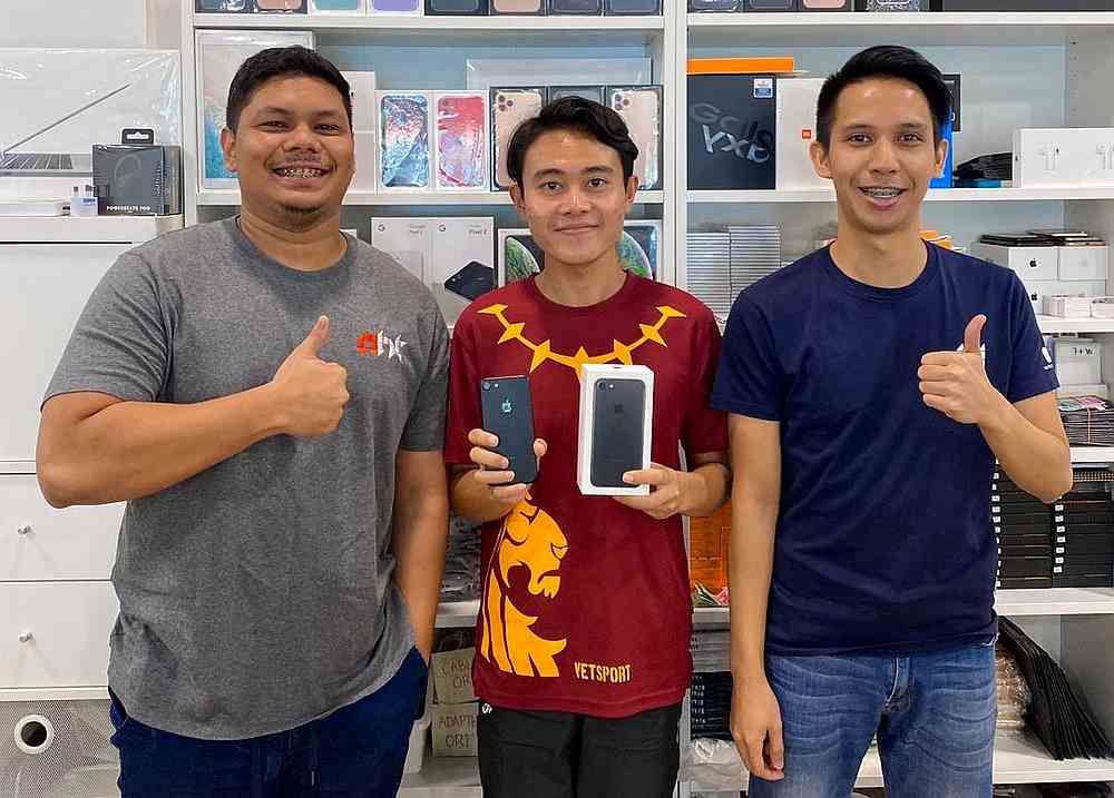 Phone seller Muhammad Asyraf Ab Rahim (left) decided to give Hafizuddin Gos Hambali (centre) a brand new gadget after reading about his academic achievements online. u00e2u20acu201d Picture from Twitter/hafizuddingh