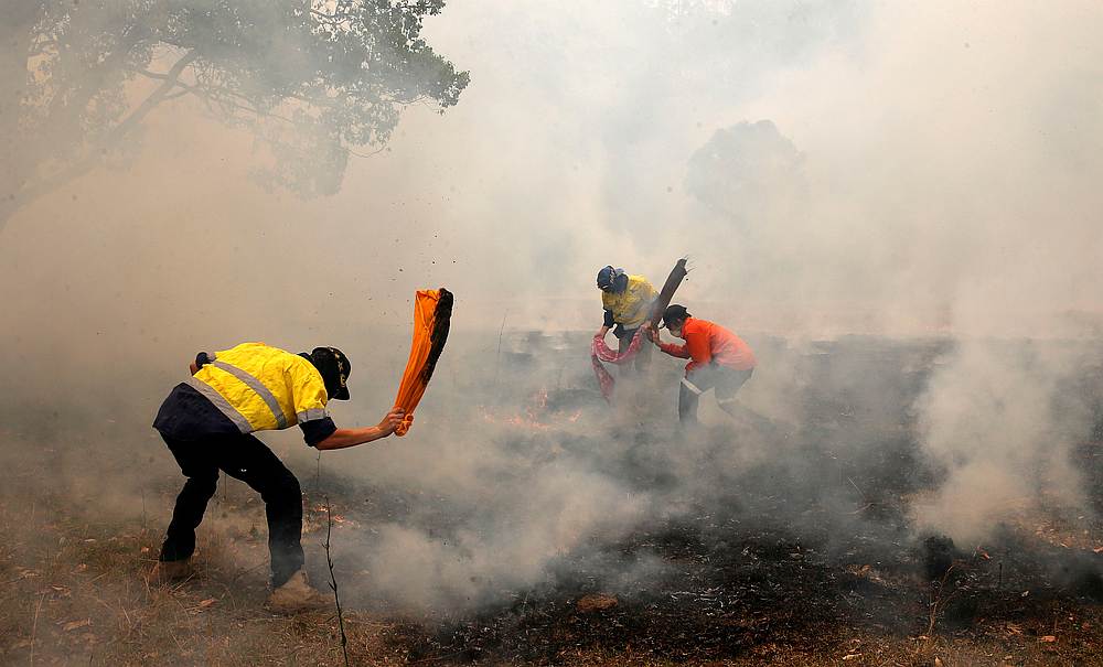 Residents try to knock down spot fires, from a bushfire, heading towards a house at Koorainghat, near Taree in the Mid North Coast region of NSW, Australia November 12, 2019. u00e2u20acu201d AAP Image/Darren Pateman via Reuters