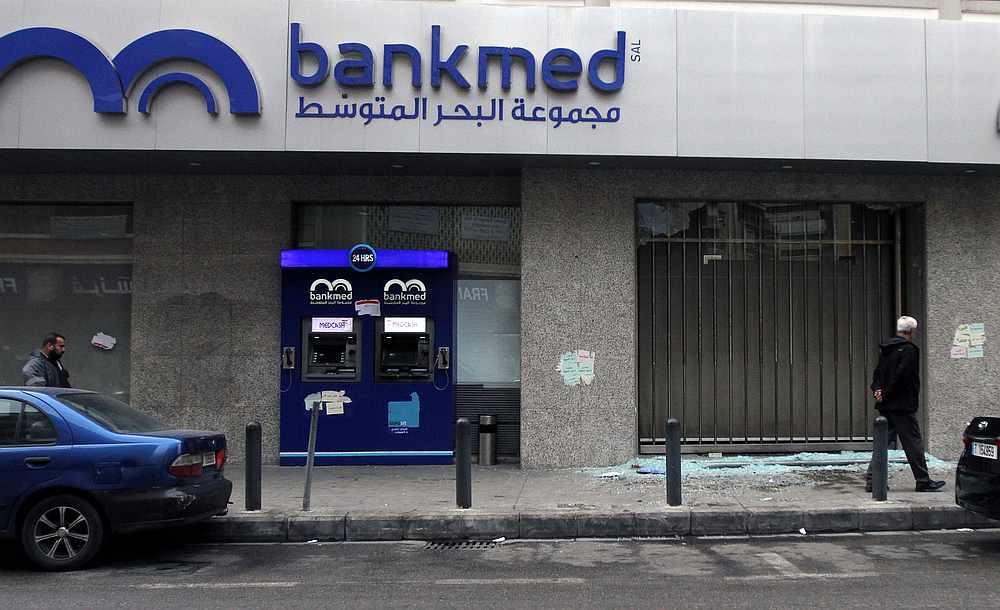 Men walk near broken glass from a damaged Bankmed branch in Tripoli, Lebanon November 27, 2019. u00e2u20acu201d Reuters pic