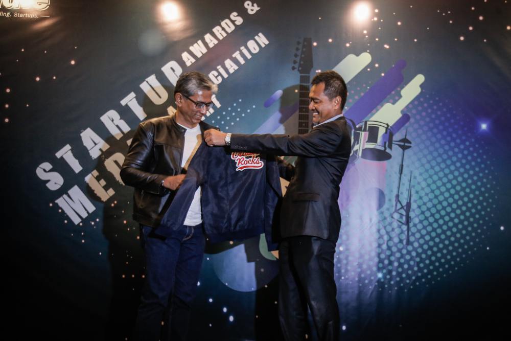 Dr Mohd Nor Azman Hassan receives a jacket from Cradle Fund Sdn Bhd Group CEO Razif Abdul Aziz during the Cradle Startup Awards and Media Appreciation Night in Kuala Lumpur November 21, 2019. u00e2u20acu2022 Picture by Hari Anggara