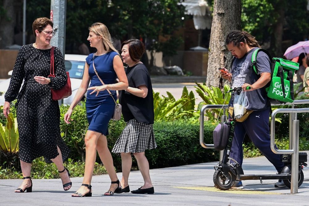 A GrabFood deliveryman checking a mobile device before riding his electric scooter along a pavement in Singapore, November 6, 2019. u00e2u20acu201d AFP pic