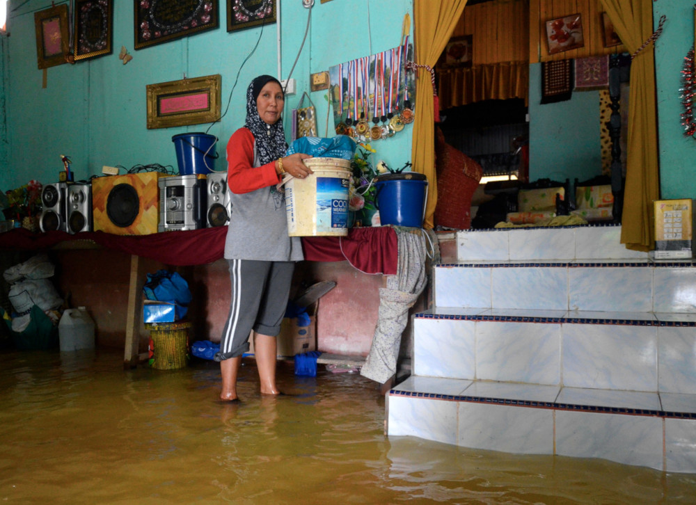 Suhaila Siram, 44, moves her belongings to a safer place after her home got inundated with floodwater in Kampung Pengkalan Ajal, Terengganu November 30, 2019. u00e2u20acu201d Bernama pic 