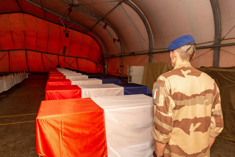 A French military of the Barkhane Force standing in front of the coffins of the 13 French soldiers who died when two French military helicopters collided in Mali, November 27, 2019 in Gao. u00e2u20acu201d James William/SIRPA handout pic via AFP 