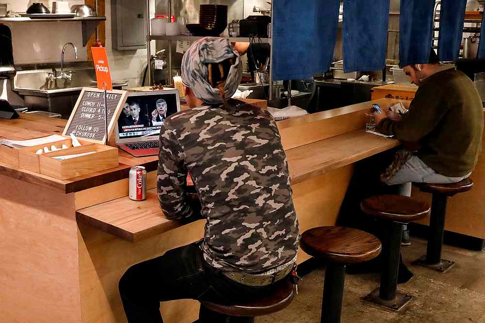 A man watches the House Intelligence Committee hearing, as part of the impeachment inquiry into US President Donald Trump, at a lunch counter in New York November 13, 2019. u00e2u20acu201d Reuters pic