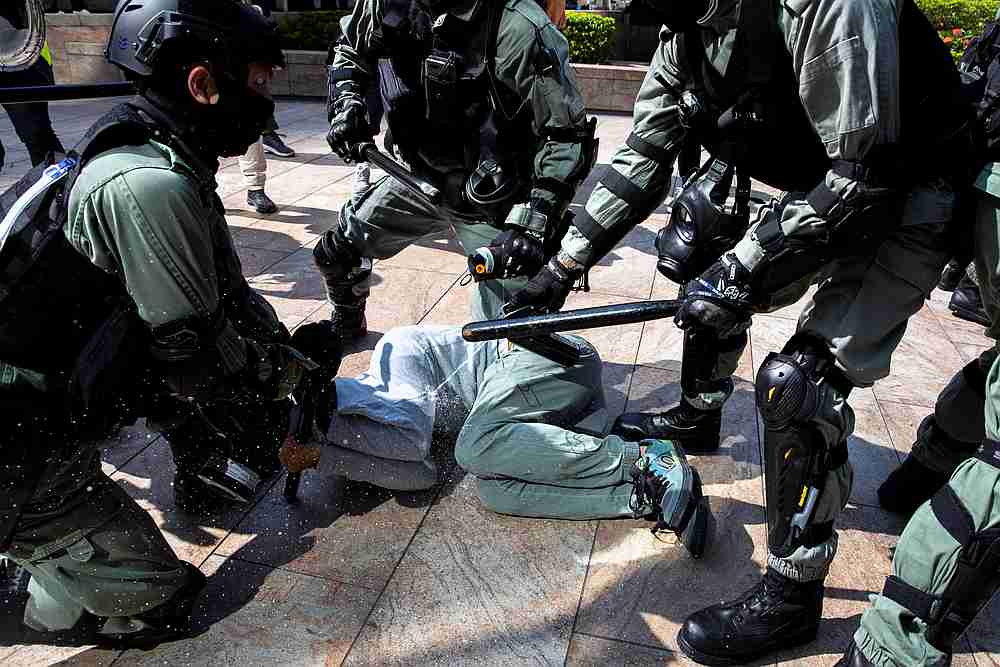 Riot police officers use pepper spray as they detain a protester during a demonstration at the Central District in Hong Kong November 13, 2019. — Reuters pic