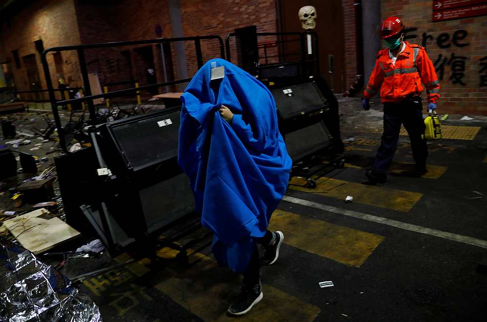 A protester is escorted by medical staff out of the Hong Kong Polytechnic University (PolyU) in Hong Kong November 20, 2019. u00e2u20acu201d Reuters pic