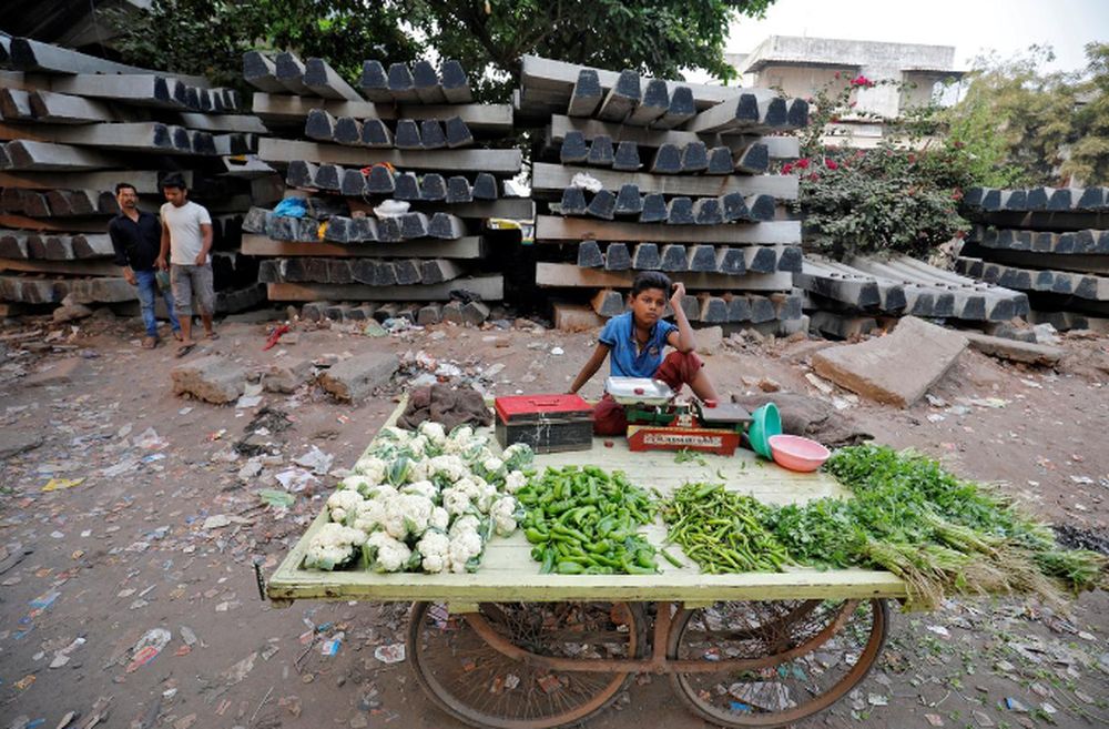 A boy selling vegetables waits for customers in front of construction material for railway tracks, at Navapura on the outskirts of Ahmedabad, India, November 28, 2019. u00e2u20acu201d Reuters pic