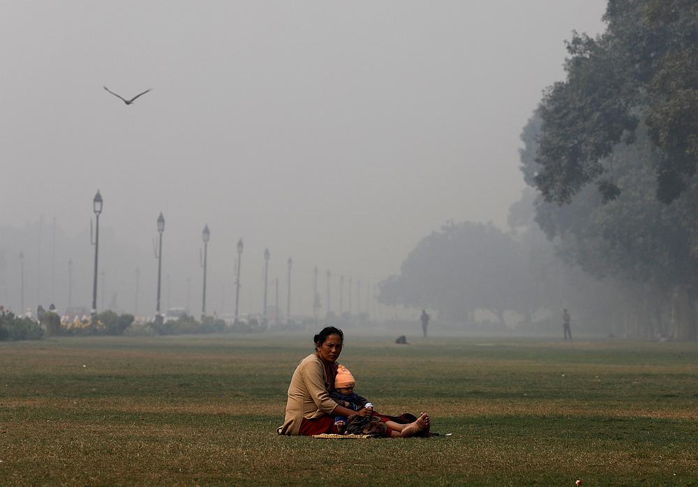 A woman sits with a child in a park near India Gate, on a smoggy morning, in New Delhi November 13, 2019. u00e2u20acu201d Reuters pic