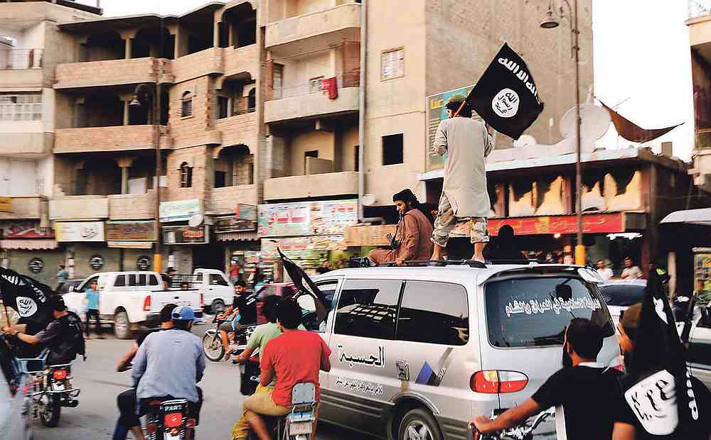 Members loyal to the Islamic State in Iraq and the Levant (Isil) wave Isil flags as they drive around Raqqa in 2014. u00e2u20acu201d Reuters pic