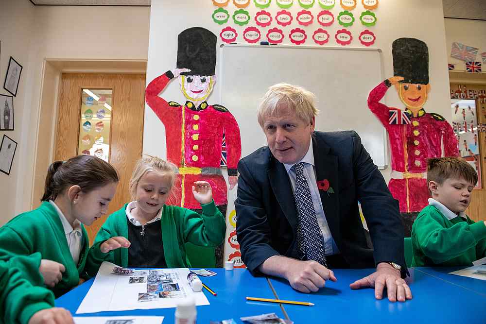 British Prime Minister Boris Johnson looks at old photographs of London with students at Abbots Green Primary Academy in Bury St Edmunds, Britain October 31, 2019. u00e2u20acu201d Reuters pic