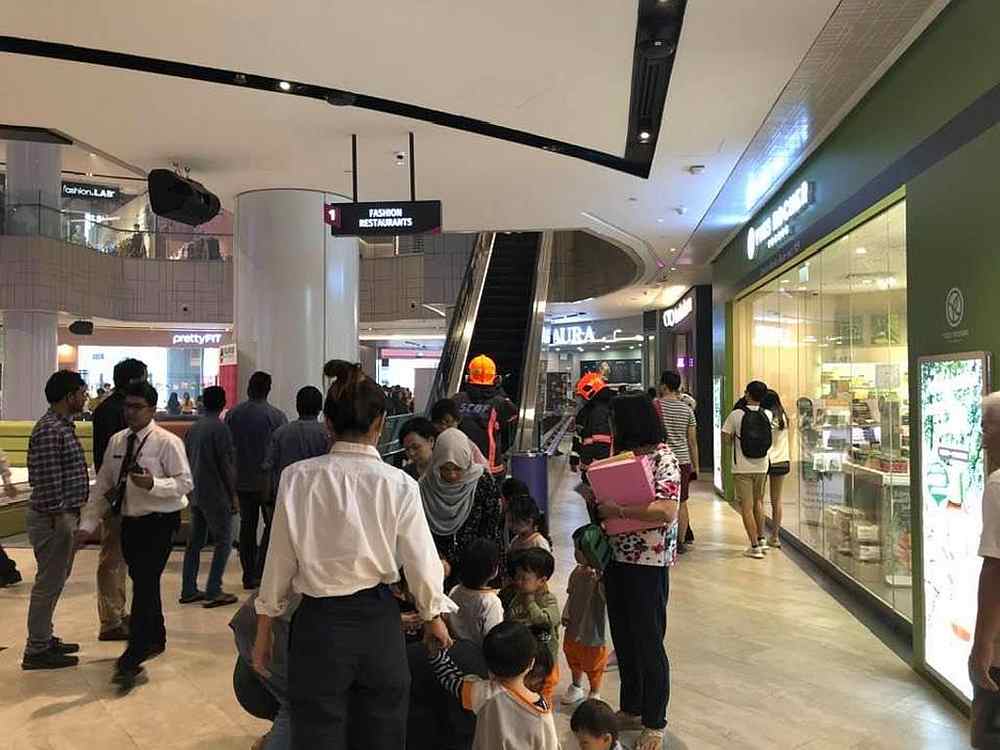People taking the escalators and leaving the building as firefighters control the situation at Singapore's Century Square shopping mall. The atrium was lightly filled with smoke November 5, 2019. u00e2u20acu201d Martin Gabriel/Facebook image via TODAY