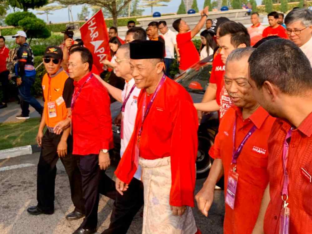 Pakatan Harapan’s (PH) candidate Karmaine Sardini (centre) and the ruling coalition’s supporters making their way to the nomination centre at the Dewan Jubli Intan in Pontian today. — Picture by Ben Tan