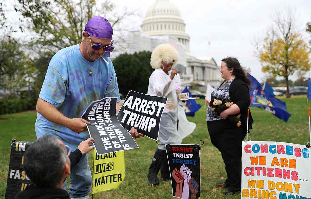 An activist is handed banners in front of the Capitol in Washington October 31, 2019. u00e2u20acu201d Reuters pic