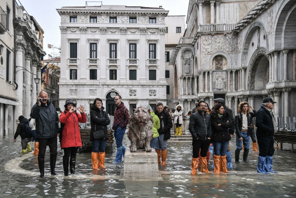 People look on from the flooded Piazzetta dei Leoncini by St. Mark's Basilica and the Palazzo Patriarcale  after an exceptional overnight u00e2u20acu02dcAlta Acquau00e2u20acu2122 high tide water level. u00e2u20acu201d AFP  pic