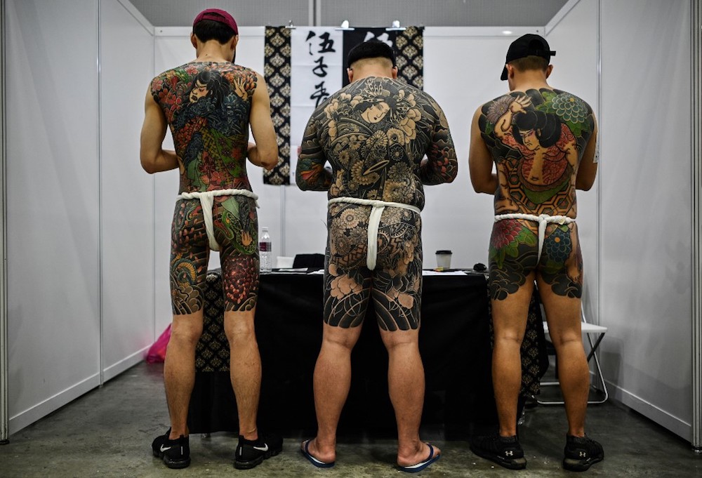 Three men display their tattoos during the Tattoo Malaysia Expo 2019 in Kuala Lumpur November 29, 2019. — AFP pic