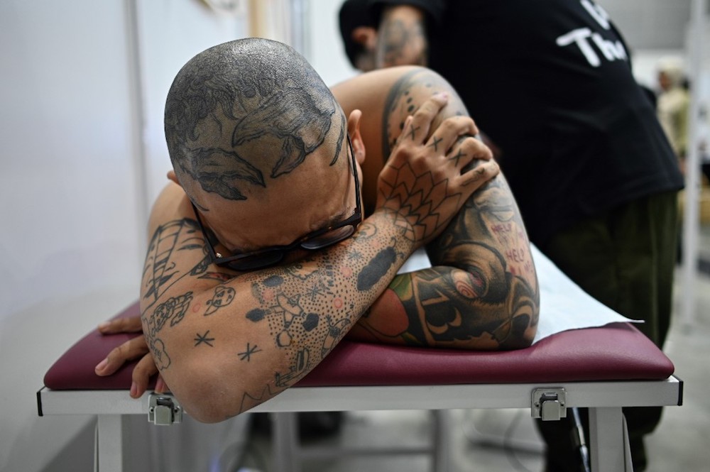 A client lies on a bed while a tattoo artist works during the Tattoo Malaysia Expo 2019 in Kuala Lumpur November 29, 2019. u00e2u20acu201d AFP pic