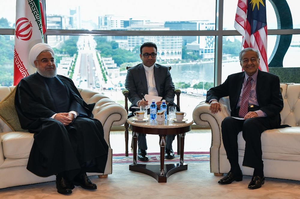 This handout photo taken and released on December 18, 2019 from Malaysiau00e2u20acu2122s Department of Information shows Prime Minister Tun Dr Mahathir Mohamad and Iranu00e2u20acu2122s President Hassan Rouhani posing for photos ahead of their meeting in Putrajaya. u00e2u20acu201d AFP pic