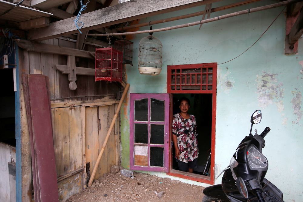 Fisherman Miskan's wife Faridah, stands by a window which has been repurposed into a door for their house, affected by land subsidence, at Tambaklorok village in Semarang, Central Java province November 27, 2019. u00e2u20acu201d Reuters pic