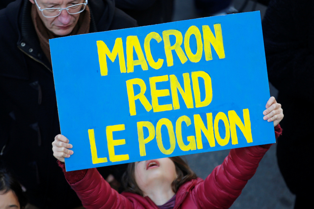 A child holds a placard during a demonstration against French government's pensions reform plans in Marseille as part of a second day of national strike and protests in France, December 10, 2019. The slogan reads u00e2u20acu02dcMacron, return the moneyu00e2u20acu2122. u00e2u20acu201d Reuter