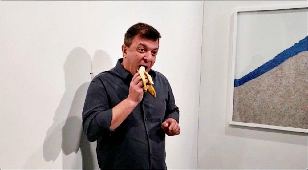 David Datuna eats a banana that was attached with duct tape to a wall, which was an artwork titled u00e2u20acu02dcComedianu00e2u20acu2122 by the artist Maurizio Cattelan, at Art Basel in Miami Beach December 7, 2019. u00e2u20acu201d Reuters pic
