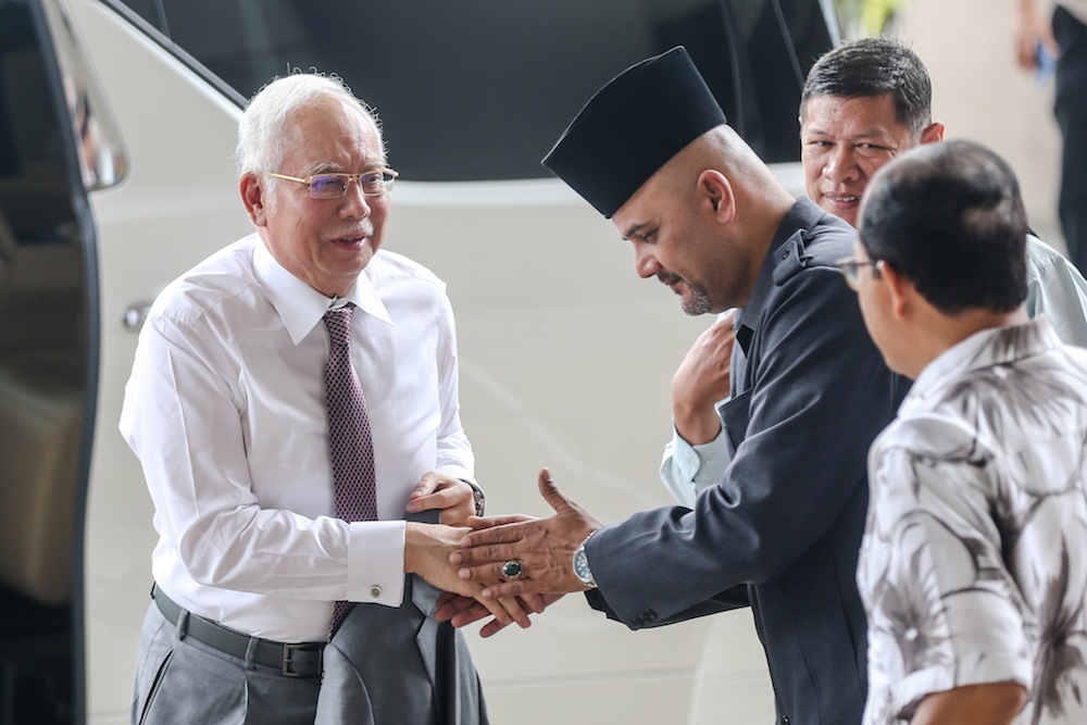 Former prime minister Datuk Seri Najib Razak is greeted by a supporter at the Kuala Lumpur High Court December 9, 2019. u00e2u20acu201d Picture by Firdaus Latif
