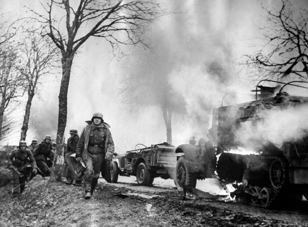 This AFP photo dated December 16, 1944 shows German infantrymen passing burning US Army vehicles somewhere on the western Front during their drive into the US lines during The Battle of The Bulge. u00e2u20acu201d AFP picn n