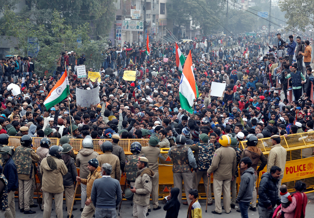 Demonstrators gather behind a police barricade during a protest against a new citizenship law in Seelampur, India, December 17, 2019. u00e2u20acu201d Reuters picn n
