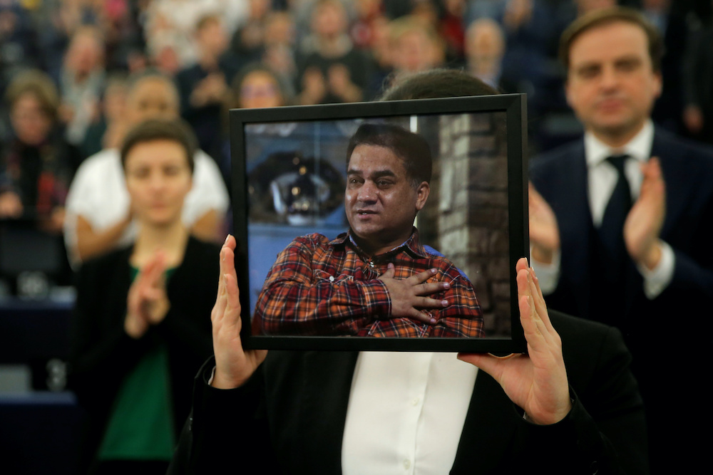 Jewher Ilham, daughter of Ilham Tohti, Uyghur economist and human rights activist, holds a portrait of her father during the award ceremony for his 2019 EU Sakharov Prize at the European Parliament in Strasbourg December 18, 2019. u00e2u20acu201d Reuters picnn