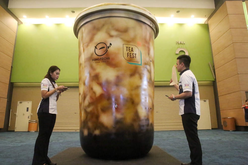 Malaysia Book of Records representatives Nurul Fatihah Mahmood (left) and Jwan Heah pictured with the boba model cup. u00e2u20acu201d Picture by Choo Choy May