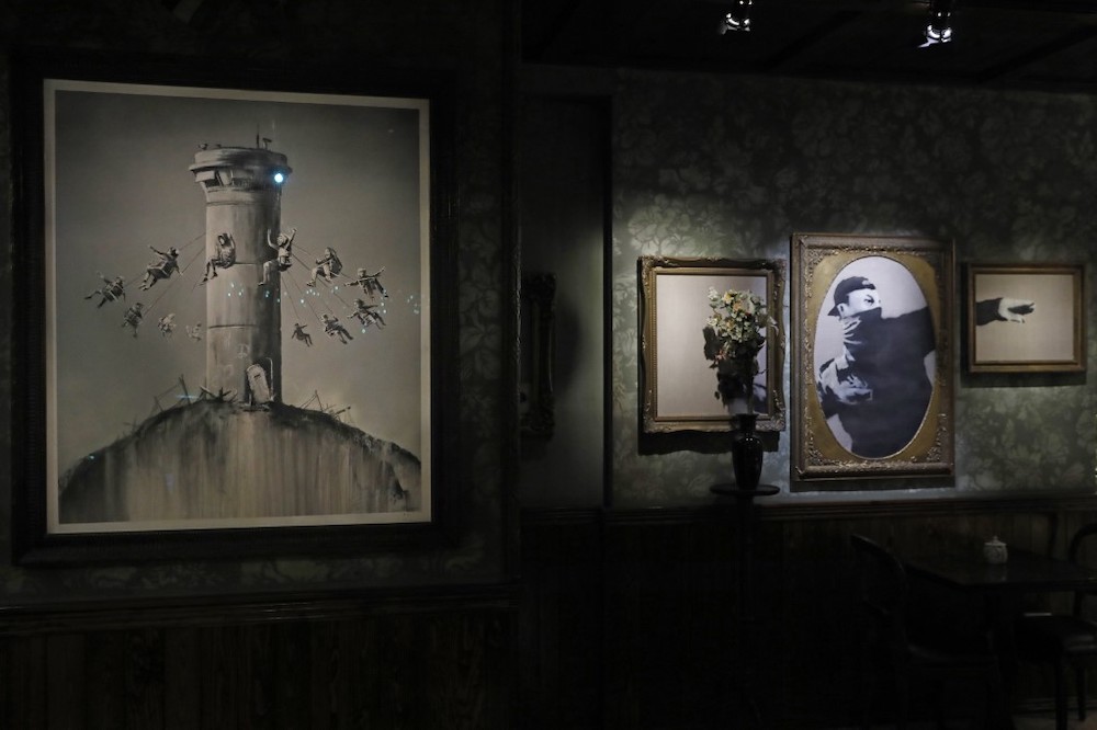 Illustrations by street artist Banksy are displayed in his Walled-Off hotel in the Israeli occupied West Bank town of Bethlehem on December 20, 2019. ― AFP pic