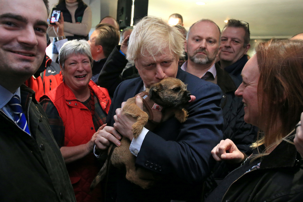 Britainu00e2u20acu2122s Prime Minister Boris Johnson kisses a supporteru00e2u20acu2122s dog during at Sedgefield Cricket Club in County Durham, England on December 14, 2019, following his Conservative party's general election victory. u00e2u20acu201d Reuters picnn