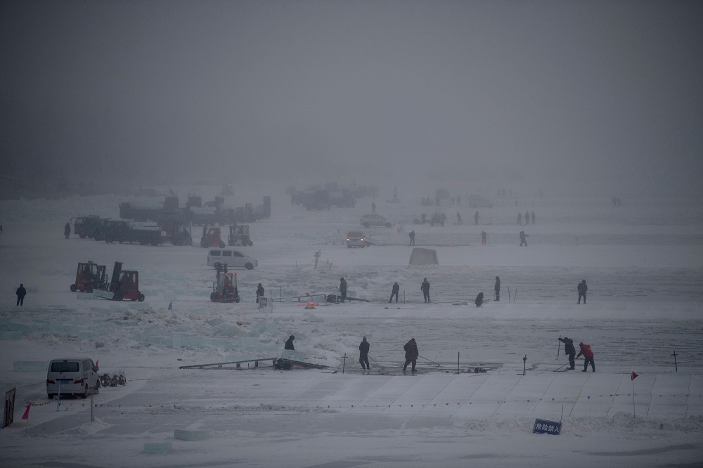 This photo taken on December 12, 2019 shows workers using picks to cut ice blocks from the frozen Songhua river in Harbin, China's northeastern Heilongjiang province. u00e2u20acu201d AFP pic  