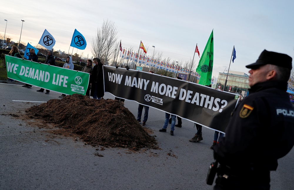 Climate change activists of Extinction Rebellion hold banners after unloading a truck filled with horse excrements in front of UN Climate Change Conference (COP25) in Madrid December 14, 2019. u00e2u20acu201d Reuters pic           