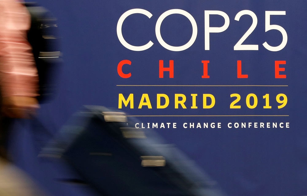 A woman carries her luggage past a sign of the UN Climate Change Conference (COP25) in Madrid December 14, 2019. u00e2u20acu201d Reuters pic           