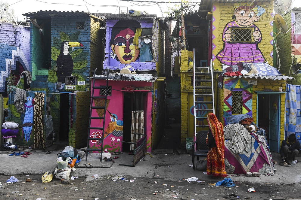 A woman walks past homes adorned with murals painted by artists from Delhi Art Street group at the Raghubir Nagar slum in New Delhi December 2, 2019. u00e2u20acu201d AFP pic