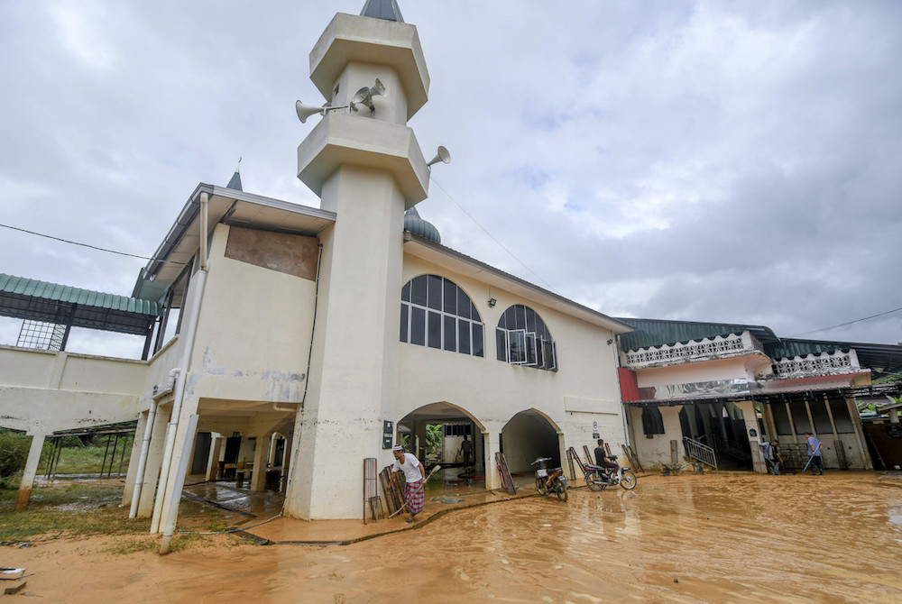 People carry out a clean-up operation at a mosque in Kampung Chenulang in Kuala Krai November 30, 2019, after it was inundated with floodwater. u00e2u20acu201d Bernama pic