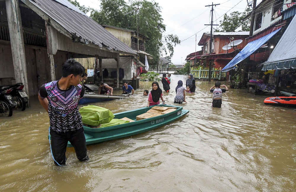 People use a sampan to transport goods along a flooded street in Rantau Panjang, Pasir Mas December 1, 2019. u00e2u20acu201d Bernama pic